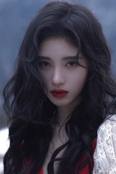 a woman with long black hair and red lipstick