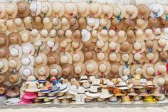 many hats are on display in front of a wall