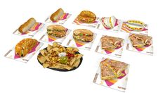 a variety of sandwiches and chips are arranged in rows