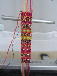 a close up of a weaving machine with beads on it