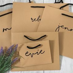 four pieces of brown paper with black writing on them and some lavender flowers in the foreground