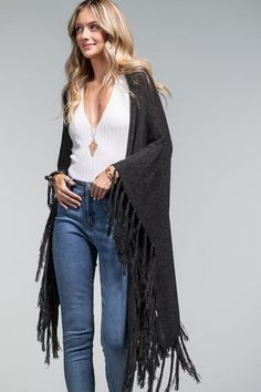 This luxurious ruana is crafted from a stretch knit fabric and features tassel accents. The open front design and absence of closures make it easy to wear. The knitted fabric offers both warmth and comfort, making it the perfect choice for fall and winter. This versatile piece can be dressed up or down for a casual boho look, and is finished off with a stylish tassel fringe border. No Armholes Shawl Sweater One Size Fits Most Stretchy Fabrication Knitted Fabric: Acrylic + Nylon Length: 31" Width Summer Loungewear, Party Bottoms, Front Fringe, Resort Chic, Shawl Sweater, Knitted Shawl, Dresses By Length, Crop Top Sweater, Vacation Dresses