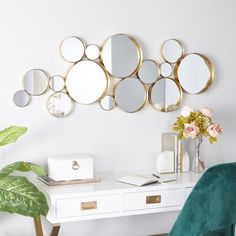 a white desk topped with a green chair and lots of mirrors