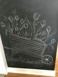 a chalkboard drawing of flowers in a wagon