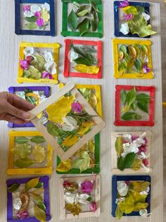 the child is playing with flowers and leaves in their art project, which includes colored squares