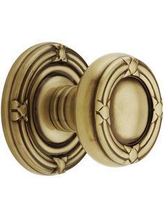 an antique brass door knob with decorative design on the front and side handles, shown from the front