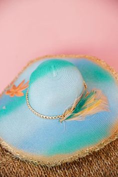 Stay stylish and shady with THE BERMUDA SUN HAT. Its floppy straw design features playful blue and turquoise stripes, accented with gold details and a shimmering palm tree patch. Plus, the gold chain band and feather combo add a touch of whimsy to any outfit. Perfect for a beach day or a stroll in the park! Blue Summer Straw Hat For Festivals, Chic Blue Straw Hat For The Beach, Chic Blue Beach Hat, Blue Bohemian Straw Hat For Summer, Blue Straw Hat With Curved Brim For Pool, Blue Bohemian Straw Hat For Beach Season, Blue Bohemian Straw Hat For Vacation, Blue Chic Straw Hat For Summer, Blue Wide Brim Straw Hat For Pool