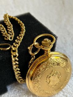 Vintage Majestron Slow Set Day/ Quick Set Date Gold Plated on Steel Quartz Pocket Watch & Chain. The pocket watch has a quartz Swiss made movement.  The pocket watch was just installed a new Swiss battery, and it is fully functional. The pocket watch dial is stamped MAJESTRON QUARTZ, at 3 there is the day/date which are working as they should.  The plastic crystal is free of scratches. The watch crown is fluted and is working properly it will open the pocket watch by pressing down the crown. It has the original chain to hold the watch. The watch case size is 48mm, and the case thickness is 16mm. The box and papers are not available. You can ask any question you might have. After buying, the payment is expected within 48 hours. After I receive payment, the item will be shipped within one bu Classic Gold Chain Watch, Gold Watches Suitable For Gifts, Gold Chain Watch As A Gift, Gold Pocket Watch With Metal Dial Gift, Gold Pocket Watch With Metal Dial As Gift, Gift Gold Pocket Watch With Metal Dial, Elegant Watch Chain As Gift, Elegant Watch Chain Accessories For Gift, Vintage Gold Pocket Watch With Metal Dial