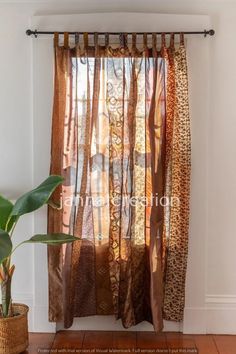 the curtains are hanging on the wall in front of the potted plant and window