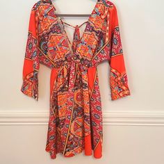 Nwt, Dress Perfect For A Concert Or Fun Night Out. Ties In The Back And Has A Deep V. Orange Sundress With Tie Back, Orange Tie-back Sundress, Orange Summer Dress With Tie Back, Orange Long Sleeve Dress For Brunch, Flowy Orange V-neck Dress, Orange Sleeveless Sundress For Party, Beach Long Sleeve Dress With Tie Back, Long Sleeve Beach Dress With Tie Back, Vibrant Print V-neck Festival Dress