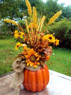 a vase filled with flowers sitting on top of a table next to a grass covered field