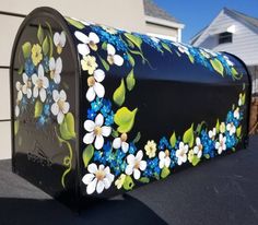 a black mailbox with flowers painted on it