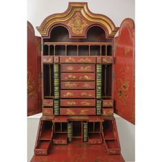 an old fashioned red and gold desk with many bookshelves on it's sides