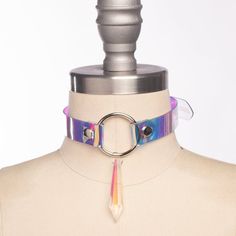 Classic choker collar in iridescent, holographic vinyl layered over PVC. An aurora borealis chandelier crystal point adorns the center o-ring. Fit is adjustable with buckle. Holes are reinforced with grommets.Collar is 3/4" wide, with a 2" crystal point.SMALL/MEDIUM (11-13")MEDIUM/LARGE (13-15")LARGE/X-LARGE (15-17")Custom sizing available.  All pieces are MADE TO ORDER, standard sizes S/M-L/XL.  If your measurements fall outside these standards or you are unsure of what size to order, select "C Iridescent Hair Accessories, Multicolor Punk Jewelry For Parties, Punk Multicolor Party Jewelry, Adjustable Iridescent Choker Jewelry, Iridescent Fantasy Jewelry For Parties, Fantasy Iridescent Jewelry For Parties, Iridescent Adjustable Necklace For Party, Iridescent Adjustable Necklace For Festivals, Adjustable Iridescent Necklace For Festivals