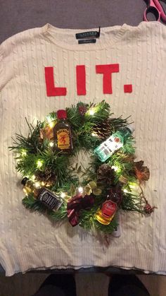 someone is holding up a sweater that says lite with pine cones and christmas lights