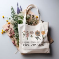 a tote bag sitting on top of a table next to flowers