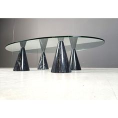 three silver cone shaped tables with glass tops