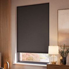 a living room with a window covered in blinds and a lamp on the side table