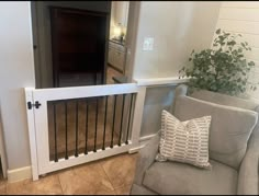 a living room with a gray chair and white railing