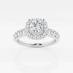 a cushion cut diamond ring with pave set diamonds on the shoulders and sides, in white gold