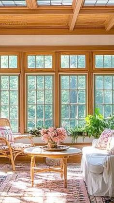 a living room filled with lots of windows next to a table and chairs in front of them