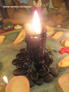 a lit candle sitting on top of a table covered in cookies and other food items