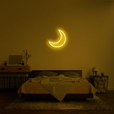 a bed in a room with a yellow light on the wall and a crescent shaped neon sign above it