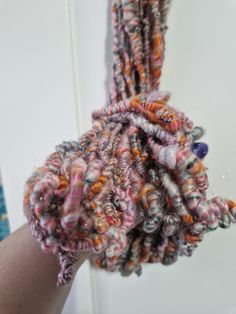 someone is holding up some yarn on their arm and it looks like they are made out of fabric