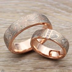 two gold wedding bands with diamonds on them