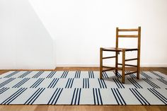 a wooden chair sitting on top of a rug next to a white and red area rug