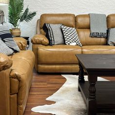 a living room with two couches, a coffee table and a cowhide rug