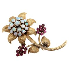 Elevate your attire with this vintage Opal & Red Gemstone Flower Brooch in 10K Yellow Gold. This timeless piece showcases an intricate flower design, made more appealing by radiant opal and red gemstones. The deep tones of the red stones strikingly contrast the delicate opals, adding depth and personality to this brooch. Secured in 10K yellow gold, its vintage elegance is enhanced. The gold is etched with beautiful details on the leaves, stem, and flower petals. These details bring this marvelous piece to life. A perfect accessory for those with refined taste! The opal gemstones have a beautiful play of color, which is sure to go with any outfit. The brooch closes securely and is sure to last for many years to come. Length: 5.5 cm Weight: 10.1g Metal: 10K yellow gold Red Stones, Antique Brooches, Vintage Elegance, Red Gemstones, Shiny Things, Red Stone, Flower Brooch, Opal Gemstone, Flower Petals