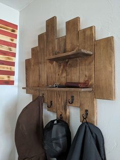 a coat rack made out of wooden planks with hooks and hats hanging on it