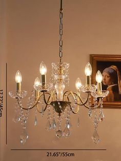 a chandelier hanging from the ceiling in a room with a painting on the wall