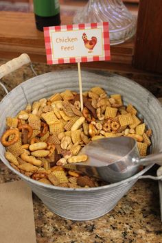 a metal bowl filled with cheetos sitting on top of a counter next to a sign