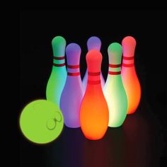 glowing bowling pins and ball in the dark with a glower on it's side