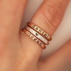 Mother's Day Gift | Pick and choose names, dates, or symbols for a three stackable ring set!  What an amazing way to commemorate an event or honor those who are important to you! See photos for examples. These rings are handmade in our Indiana studio. Each engraved ring starts from a spool of wire. They are handcut, handformed and soldered in the first process of creating your ring. They are then hammered to size, engraved, handbrushed, and polished. Each ring will have a small solder spot in th Mom Rings Stackable, Mom Rings, Personalized Stackable Rings, Stackable Name Rings, Mother's Ring, Stackable Ring Sets, Typewriter Font, Mom Ring, Engraved Ring