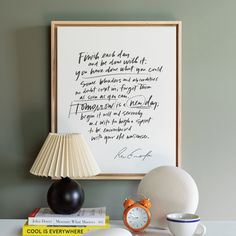 a table with books and a lamp on it next to a framed print that reads, i trust each other