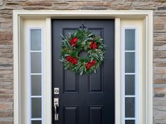 a black front door with a wreath on it