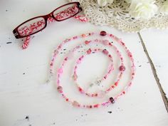 "This Pink Eyeglass Chain can also be worn as a necklace. Ralston Originals was the first to add the lobster clasp at the end of the eyeglass chain to join it together to make a Necklace. Brilliant! This makes it even more convenient because you now have two pieces of jewelry in one, and eyeglass chain for your glasses, and a beaded necklace!! The chain is made with an assortment of sizes and colors of pretty pink glass beads, and pink seed beads. The ready made chain is 26 or 32 inches long, or Pink Glass Beaded Necklaces For Gift, Pink Glass Beaded Necklace For Gift, Pink Glass Beaded Chain Jewelry, Pink Glass Jewelry With Beaded Chain, Pink Czech Glass Beaded Necklace For Gifts, Adjustable Clear Beaded Necklace For Gifts, Adjustable Pink Glasses Chains As Gift, Adjustable Clear Beaded Necklaces As Gifts, Handmade Pink Glass Beaded Necklaces