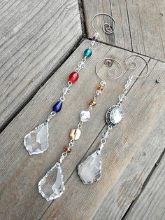 three pieces of jewelry sitting on top of a wooden table