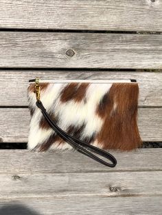 The Fleuri makeup bag or mini clutch is a great little versatile bag that is perfect for your phone, credit card and keys or to use as a stylish makeup bag.  Dimensions: Height: 12cm (4.7in) Width: 20.5cm (8in) Flat construction It is made from fluffy ( not flat)  tricolour brown and white cowhide on the front with soft brown leather on the back. The Fleuri has a fawn, starry cotton lining on the inside and a pretty YKK gold colour zip with a leather tassel pull (not shown in all photos) or a le Brown Handheld Mobile Phone Pouch, Handheld Brown Mobile Phone Pouch, Brown Clutch Mobile Phone Bag, Brown Handheld Clutch With Mobile Phone Bag, Brown Cow Print Bag For Everyday Use, Brown Clutch Pouch For Mobile Phone, Brown Mobile Phone Bag Clutch, Brown Mobile Phone Clutch Pouch, Brown Mobile Phone Pouch Clutch