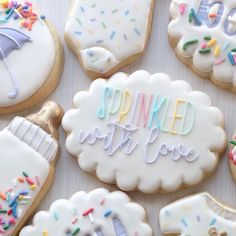 decorated cookies with frosting and sprinkles are arranged on a white surface