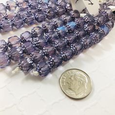 a penny sitting next to some purple glass beads