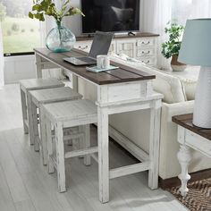 a living room filled with furniture and a flat screen tv on top of a wooden table