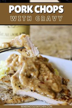 grilled pork chops with gravy on a white plate next to a bottle of wine