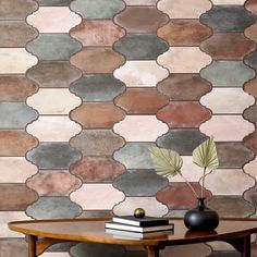 a coffee table with a vase on it next to a wallpapered background that looks like tiles