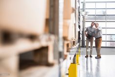 two people standing in a warehouse looking at something