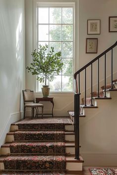 there is a potted plant sitting on the stair case next to the window in this house