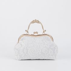 The Vintage Lacy Bag is a modern twist on the vintage designs of yesteryear. It features a vintage clasp closure, an elegant lacy floral exterior, and a beautiful intricate design metal flower handle. The feminine touch of the exterior blends in nicely with any outfit and is roomy enough to hold all of your items. Brin Luxury Vintage Engraved Bags, Hand Bag Luxury, Lace Bags Vintage, Elegant Clutch Evening Bag For Vintage Events, Elegant Evening Bag For Vintage Events, Elegant Clutch Bag For Vintage Events, Vintage Wedding Bag With Detachable Handle, Vintage Wedding Shoulder Bag With Detachable Handle, Elegant White Evening Bag With Top Carry Handle